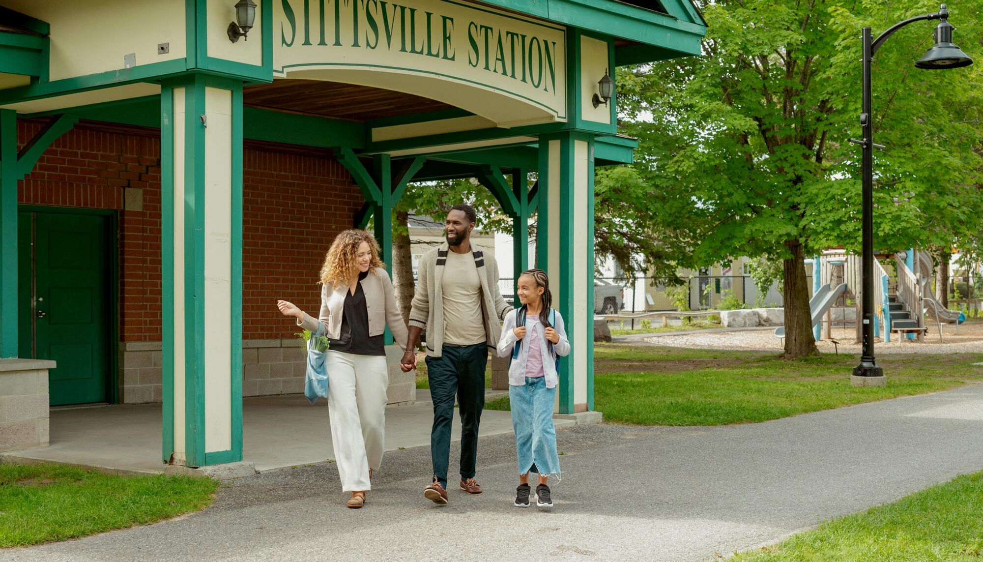 A family walking past the Stittsville Station building.