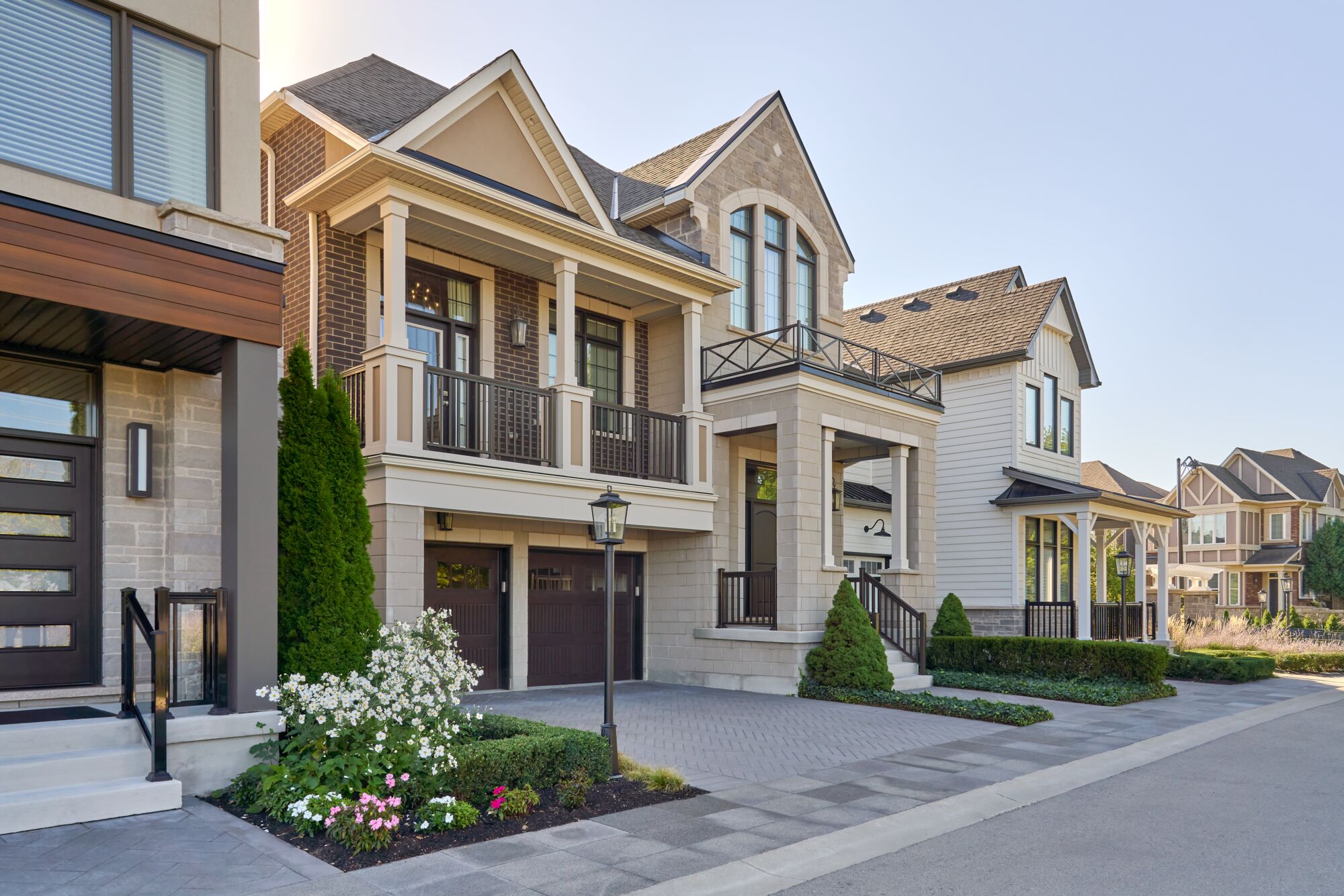 A row of finished home exteriors with driveways and front gardens.