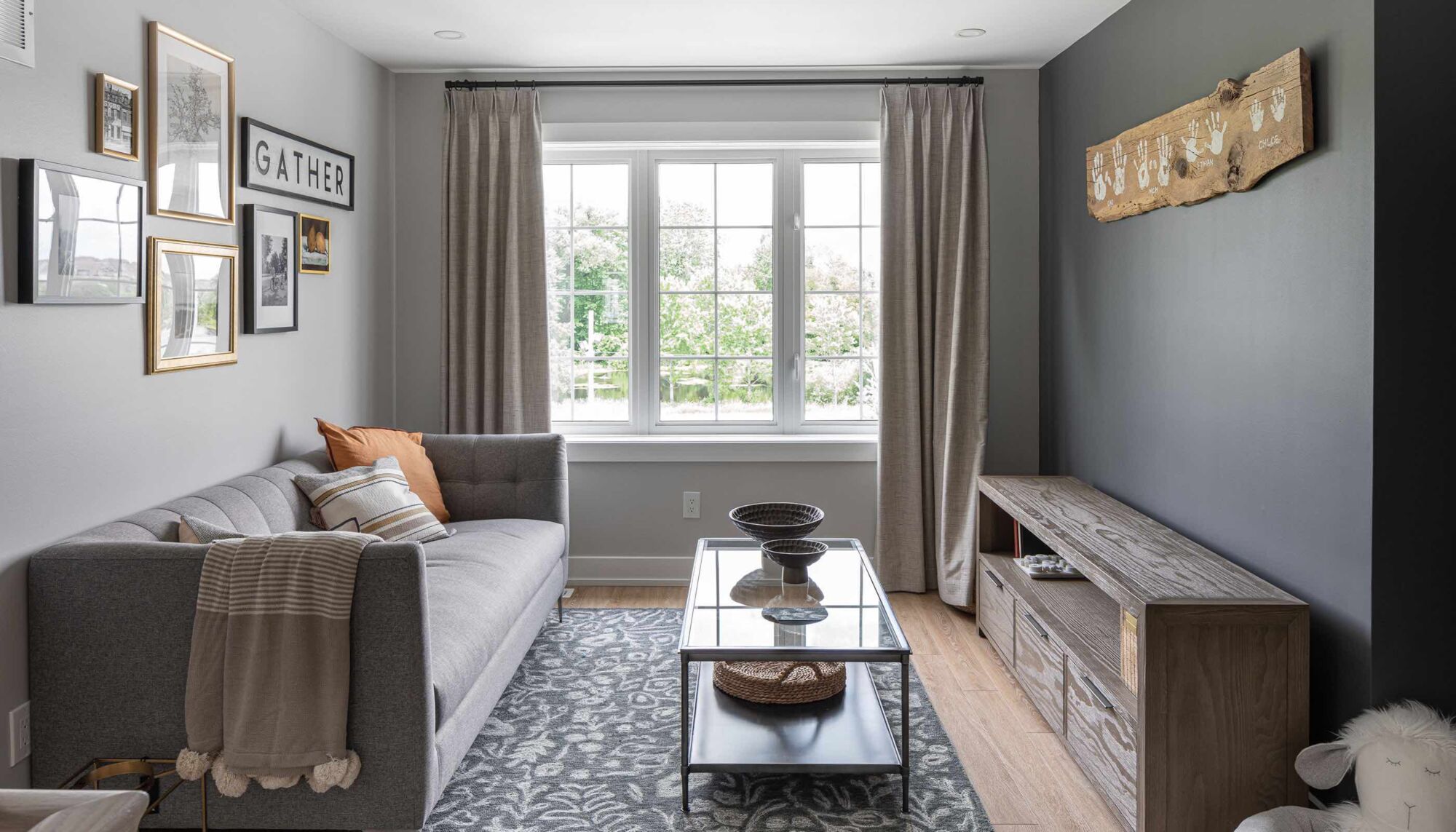 A furnished living room with a sectional sofa and a large window.