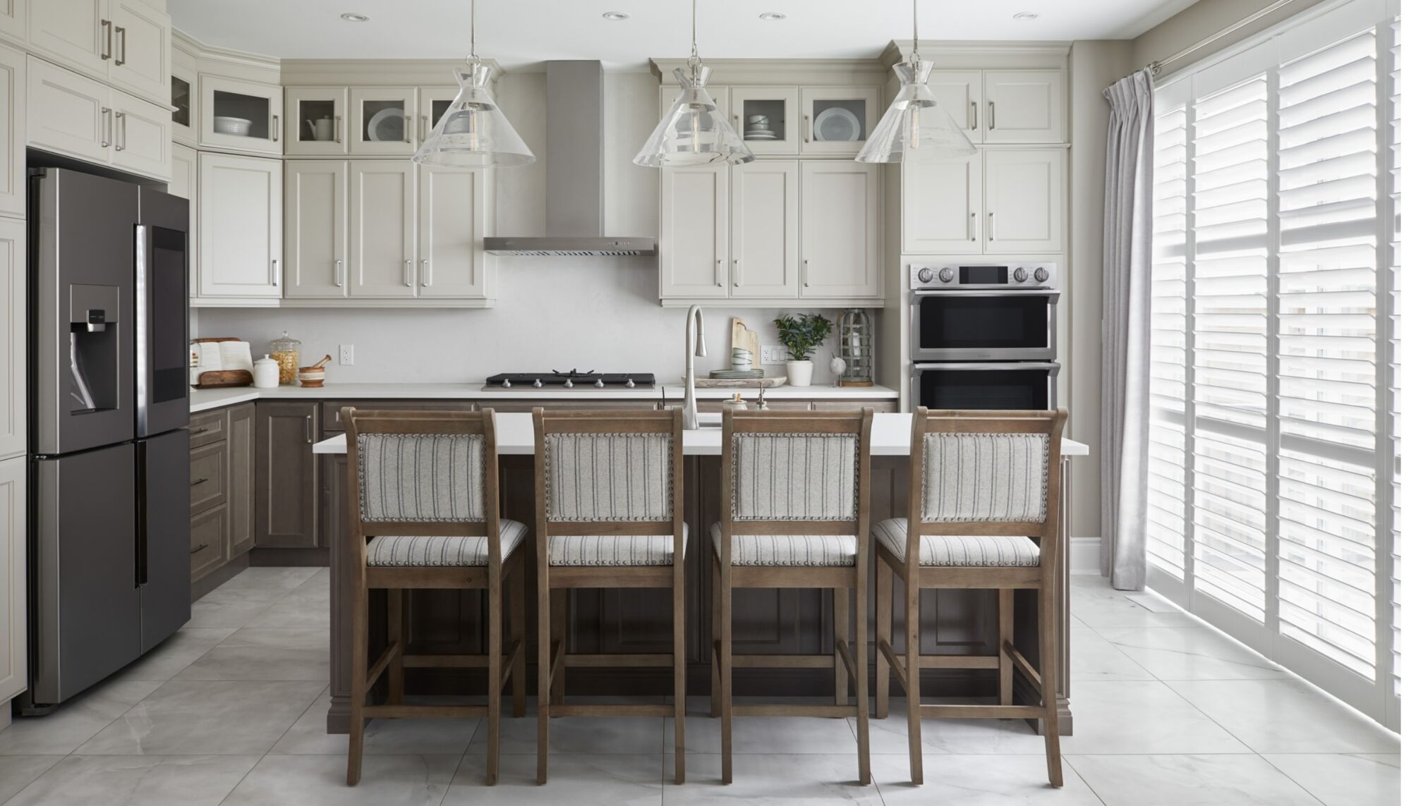 A white kitchen with an island and breakfast stools.