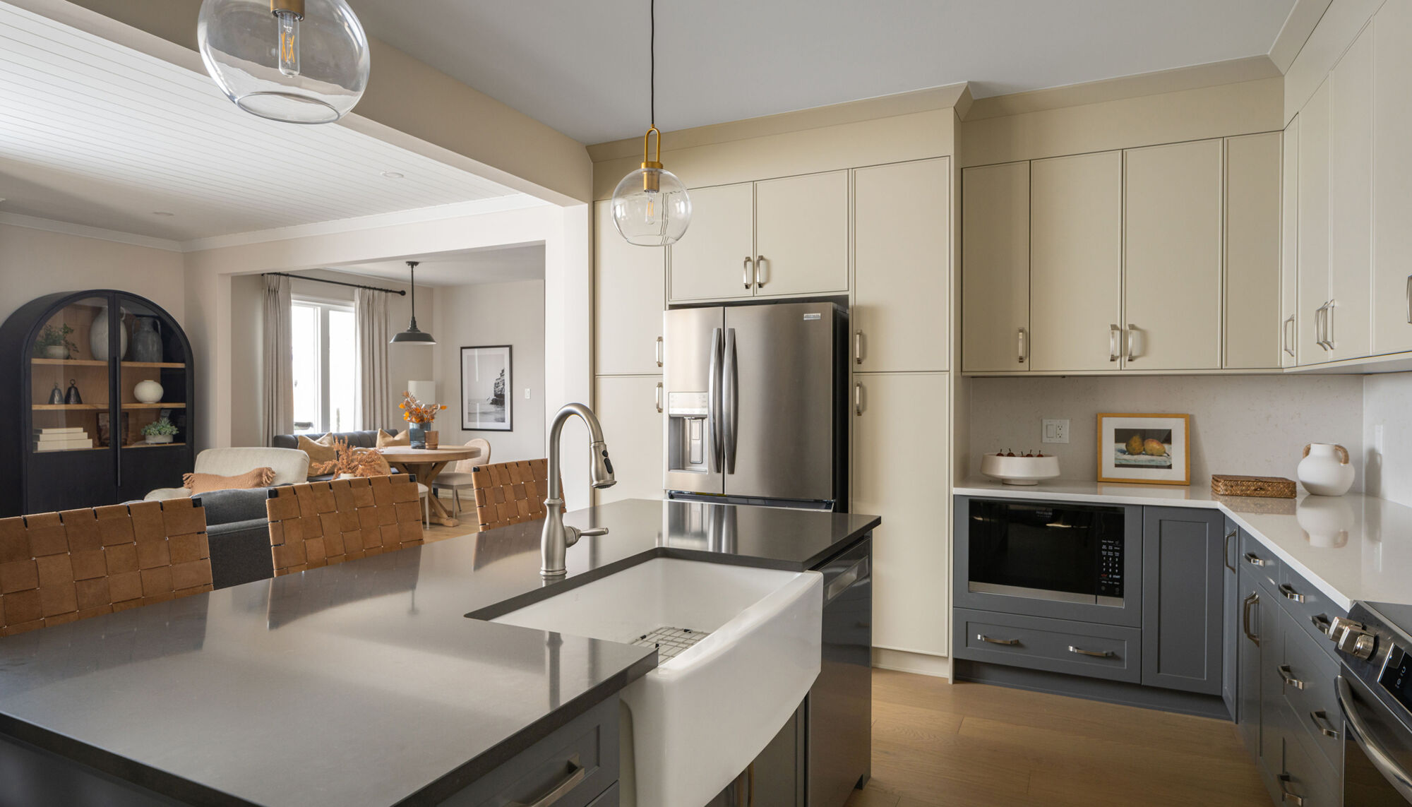 A kitchen and living space with light cabinetry and an island.