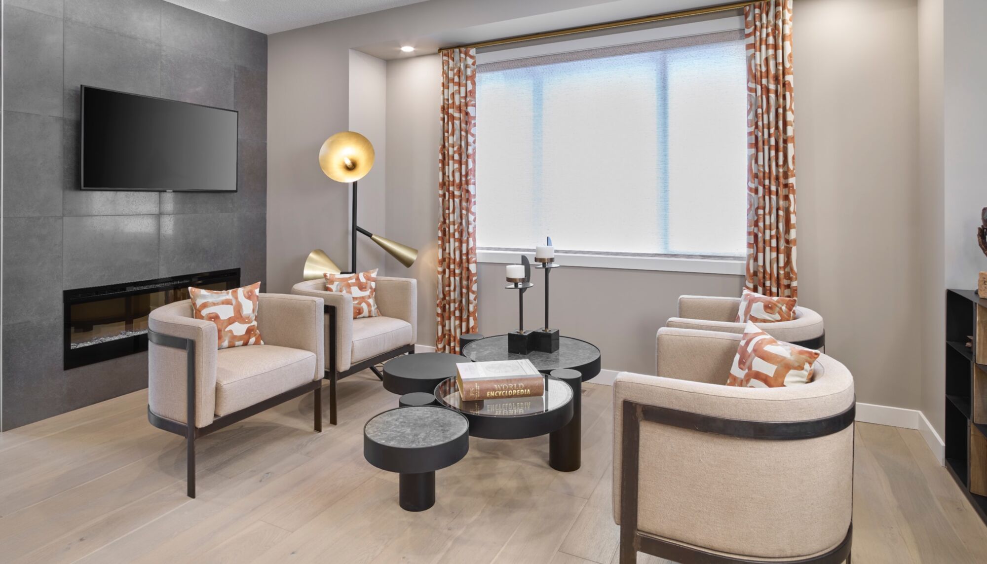 A sitting room with upholstered chairs and a wall-mounted television.