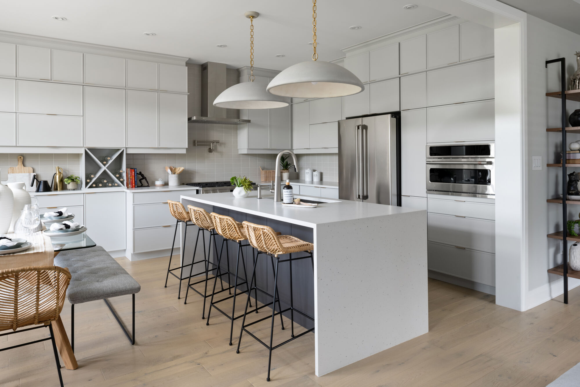 A bright model-home kitchen with white cabinets and a long island.
